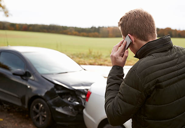 A man calling his lawyer after being involved in a car accident